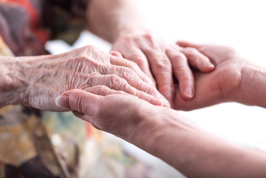 Mains d'une personne âgée tenues avec bienveillance
